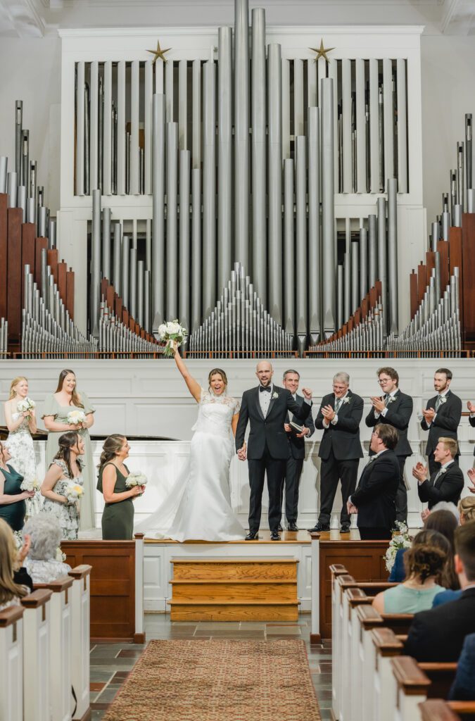 Wedding ceremony at Reid Chapel in Birmingham Alabama with bride and groom celebrating at the alter