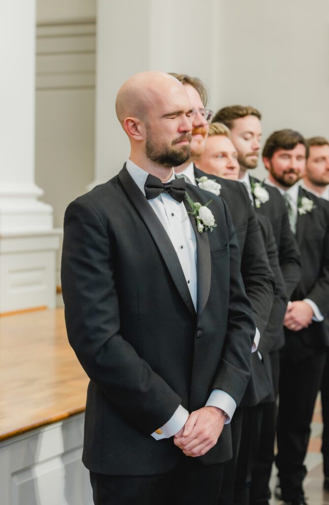 Emotional groom at wedding ceremony at Reid Chapel in Birmingham Alabama while the bride walks down the aisle