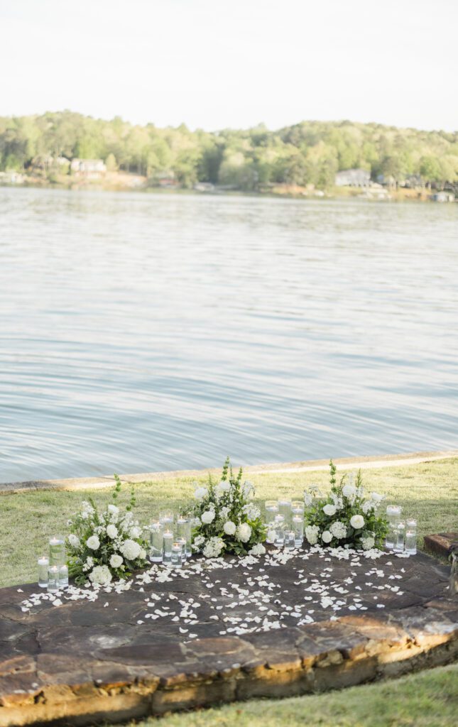 romantic proposal setup at Smith Lake Alabama with candles rose petals and champagne by the water