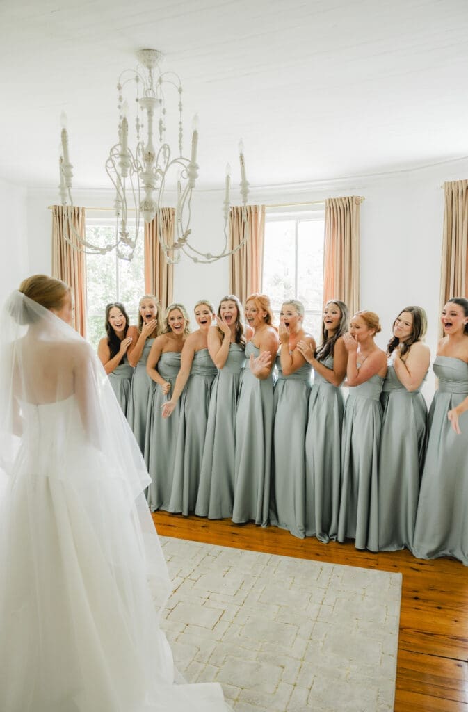 Bridesmaids reacting emotionally to bride’s wedding dress reveal