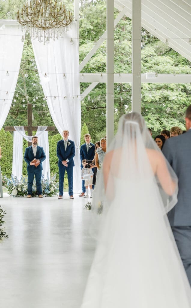 Bride walking down aisle with veil down during wedding ceremony