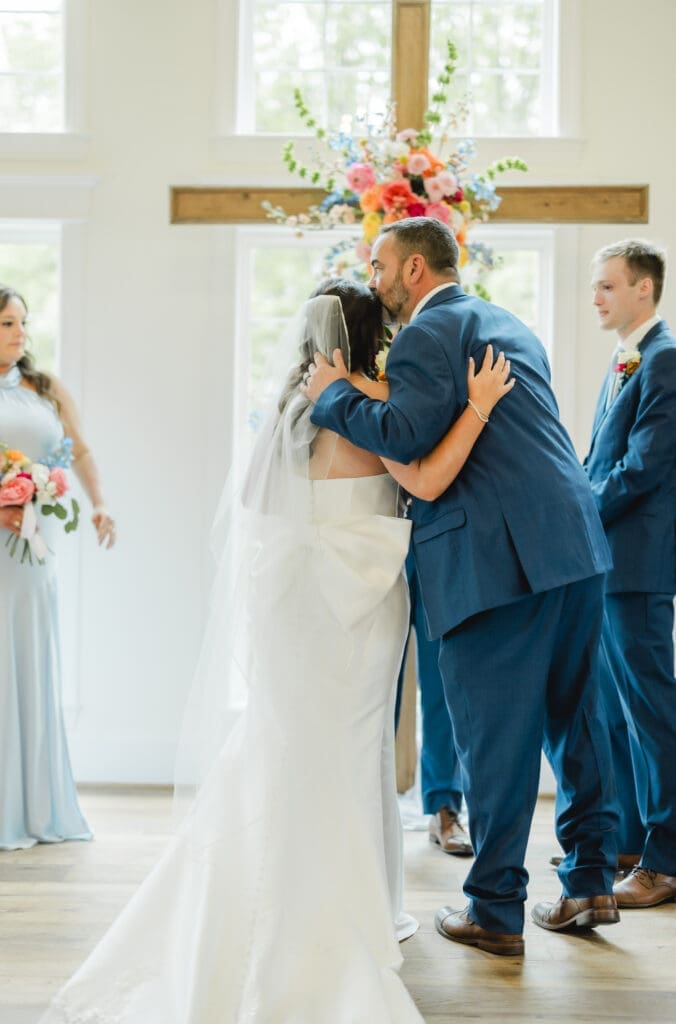 Bride walking down the aisle in white chapel ceremony
