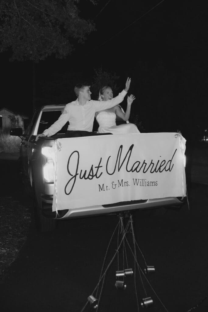 Newly married couple celebrating getaway exit after reception