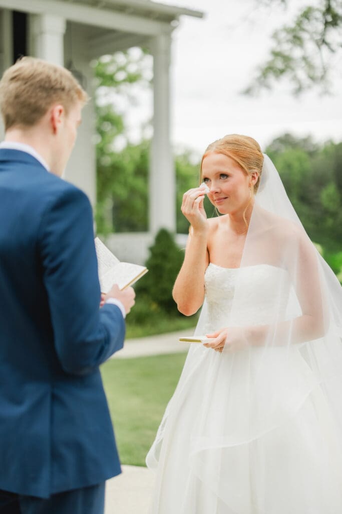Bride and groom reading private vows before wedding ceremony