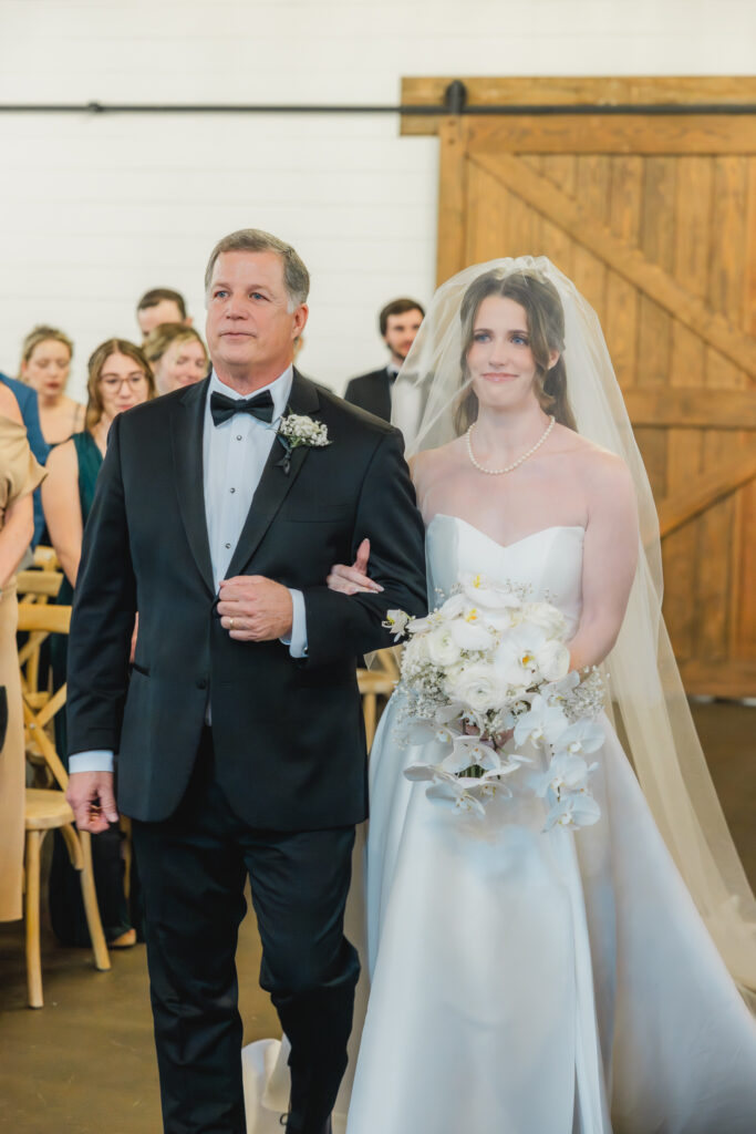 Bride walking down the aisle during an elegant Ridge Pointe wedding ceremony.
