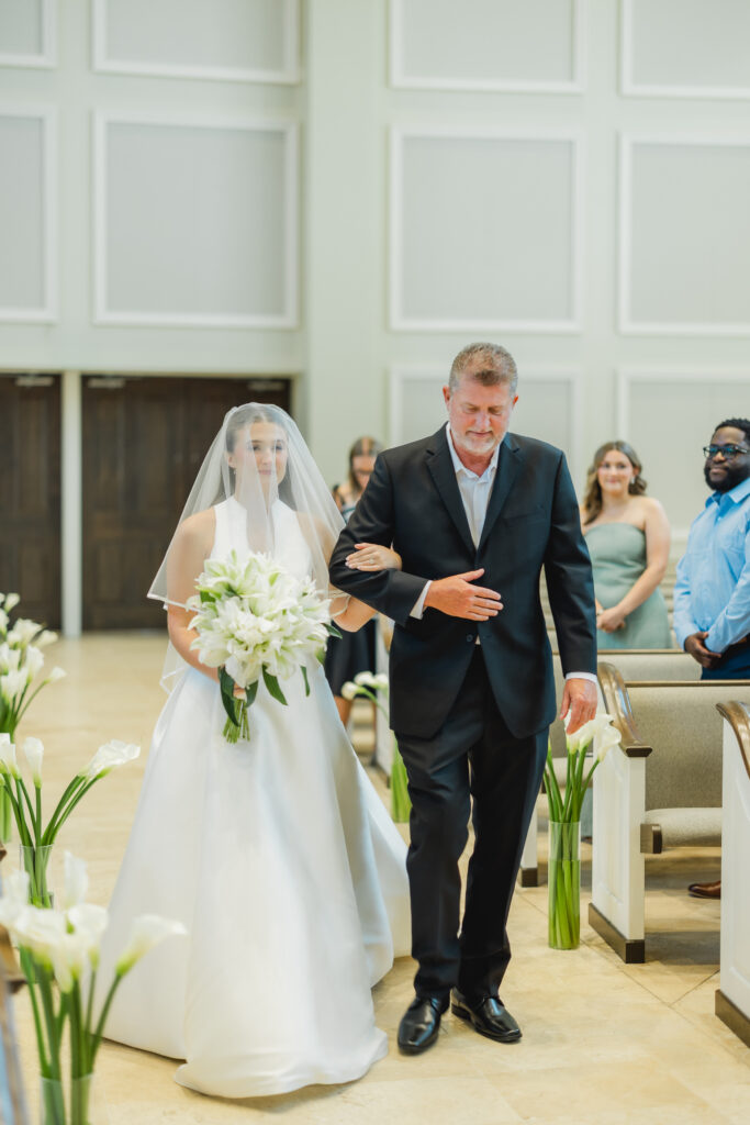 Kendall walking down the aisle toward Luke during their Church of the Highlands wedding ceremony