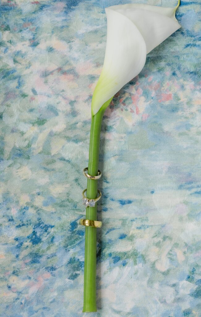 Kendall and Luke’s wedding rings photographed with a white calla lily at their Birmingham Alabama wedding