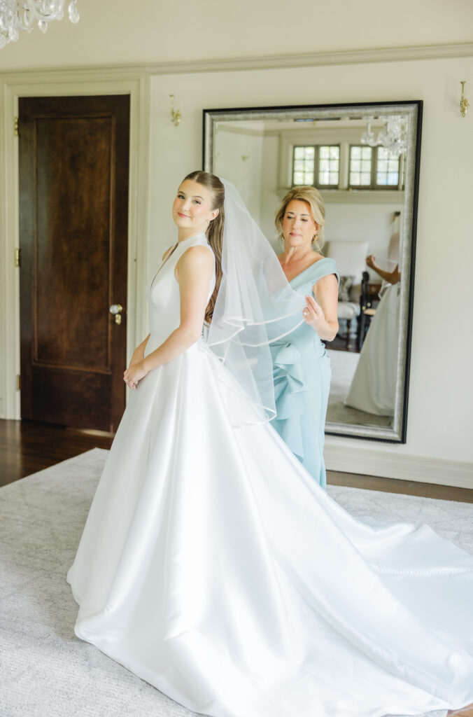 Kendall smiling in her wedding dress with mom before leaving Clubhouse on Highland for her Birmingham wedding