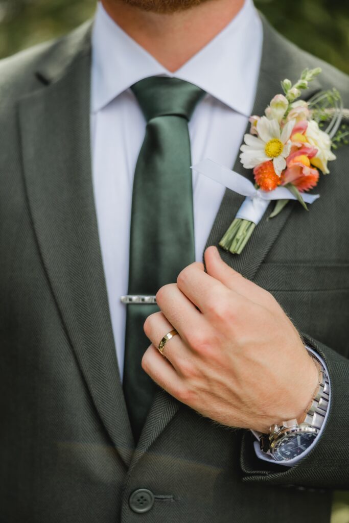 Groom wearing a dark green suit at The Barn at Smith Lake
