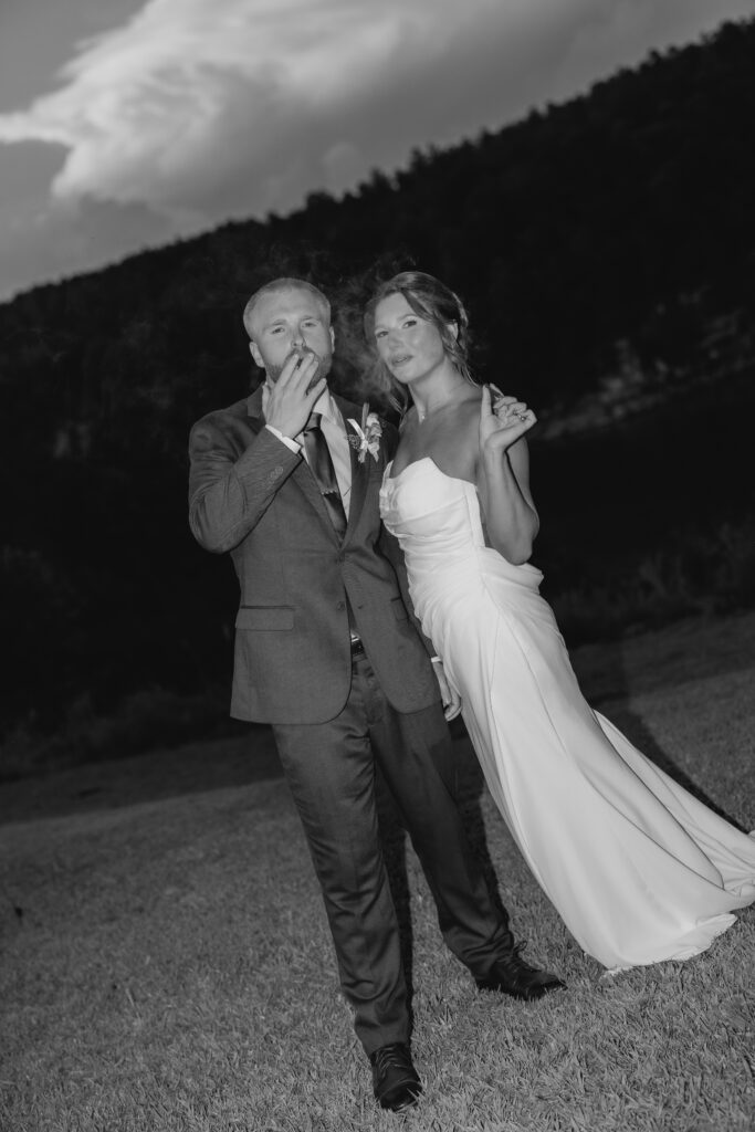 Bride and groom Jess and Jack smoking a cigar with her wedding party at The Barn at Smith Lake