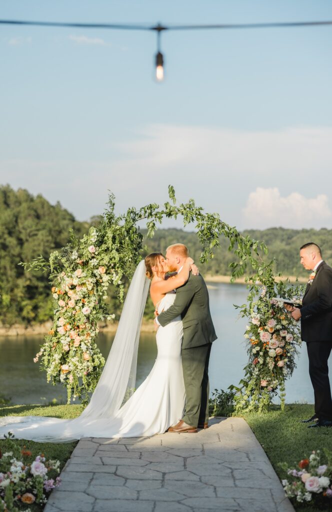 Bride and groom first kiss at wedding ceremony on Smith Lake