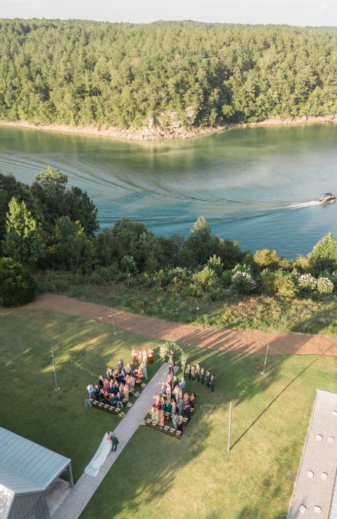 Aerial drone photo of bride walking down the aisle with a boat passing on Smith Lake