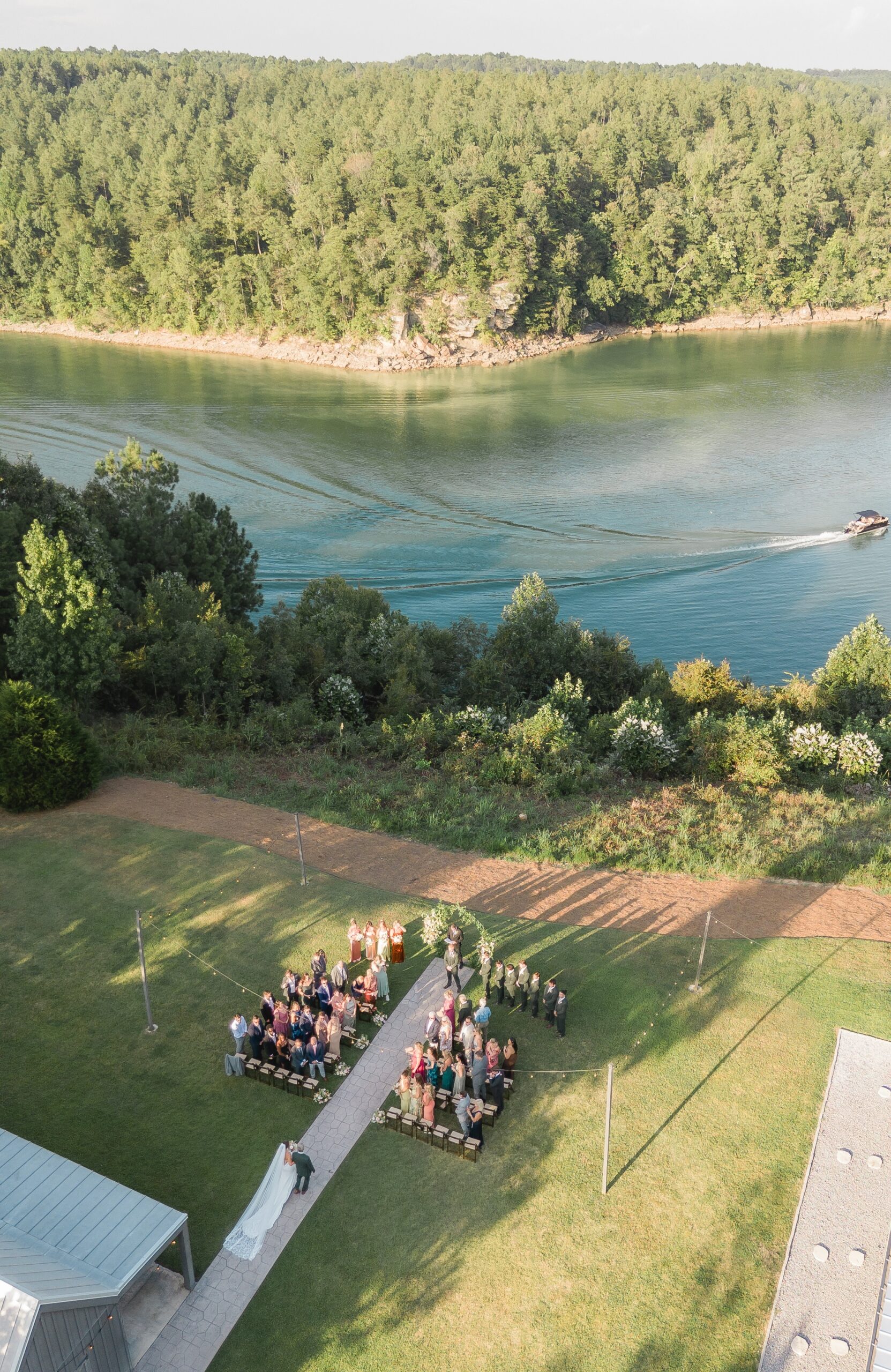 Aerial drone photo of bride walking down the aisle with a boat passing on Smith Lake