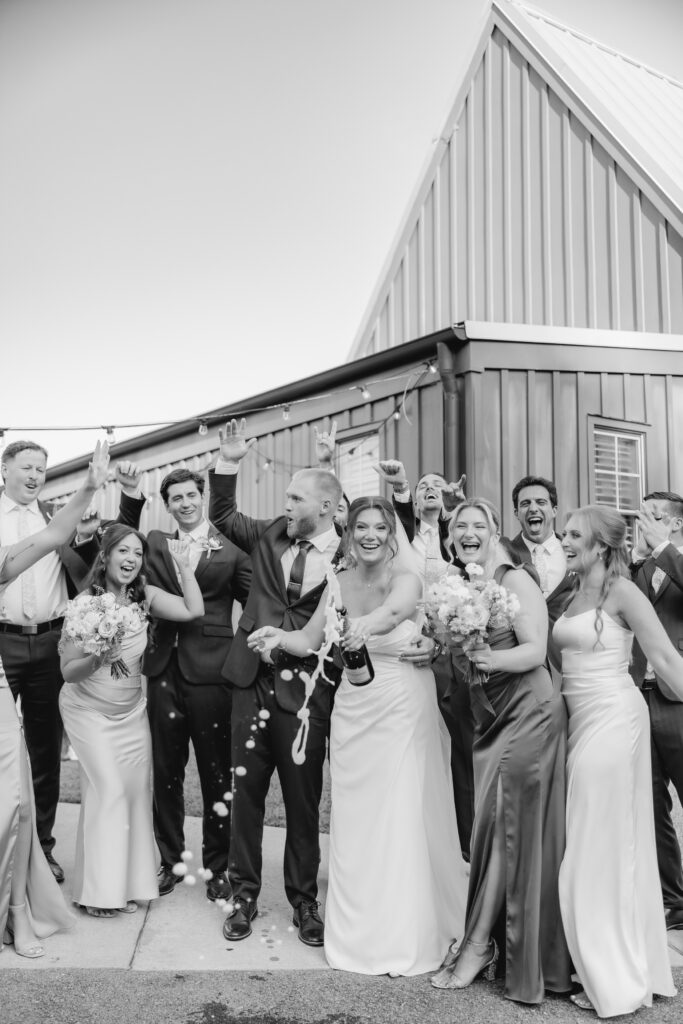 Wedding party celebrating with champagne after the ceremony at The Barn at Smith Lake