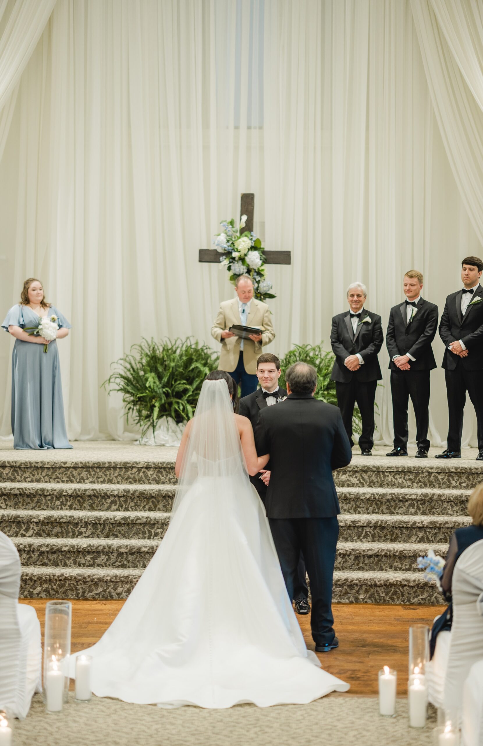 Abby walking down the aisle toward Jonathan on their wedding day.