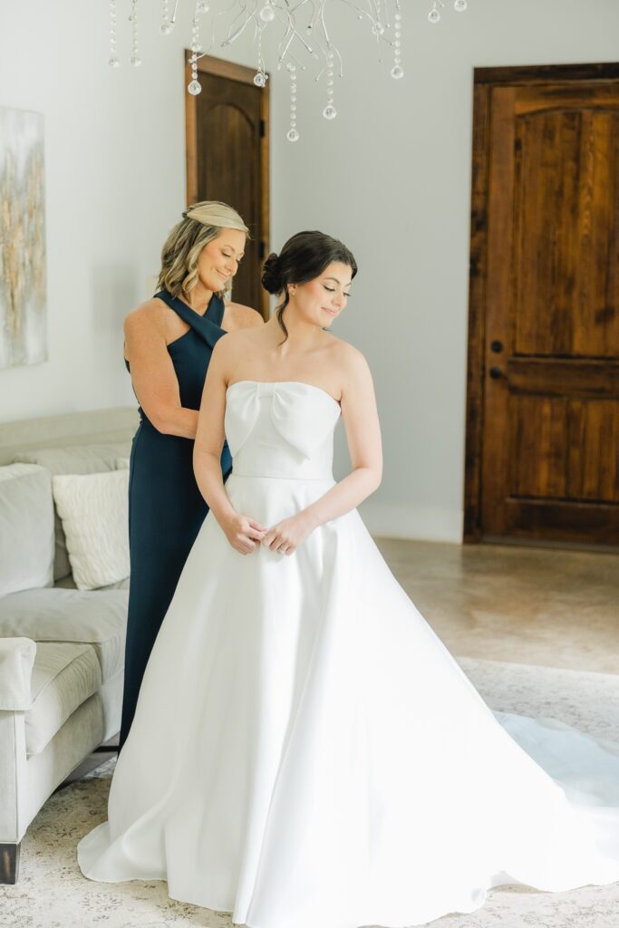Abby’s mom helping her into her wedding dress before the ceremony.