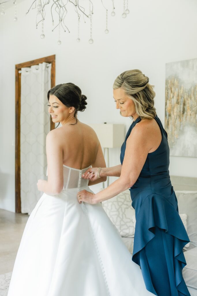 Abby’s mom helping her into her wedding dress before the ceremony.