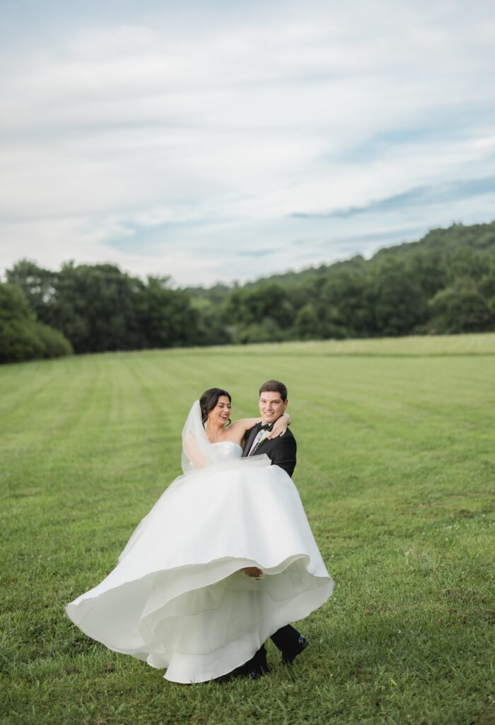 Abby and Jonathan embracing as the evening light falls over the Alabama landscape.